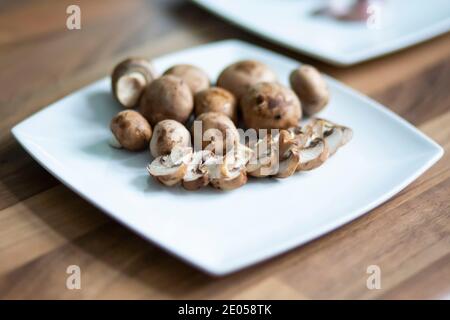 Funghi di castagno su un piatto bianco Foto Stock