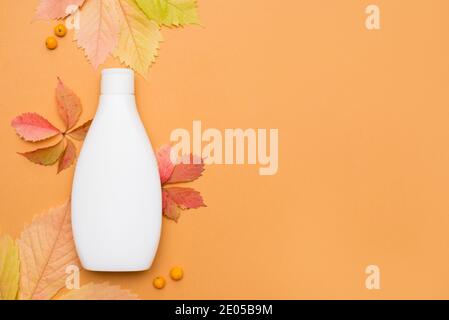 foglie di acero giallo autunno, shampoo naturale organico. Bellezza mockup Foto Stock