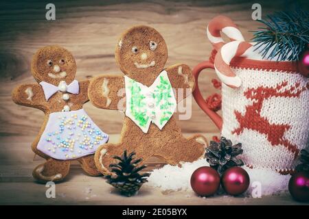 Bella tazza di Natale e gingerbread man sul tavolo di legno Foto Stock