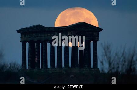 La luna piena di dicembre si trova dietro il monumento a Penshaw, vicino a Sunderland. In altre parti del Regno Unito, il MET Office ha emesso nuove avvertenze per la neve per mercoledì, con la possibilità di causare chiusure di ferrovie e strade, interruzioni di corrente e lesioni. Foto Stock