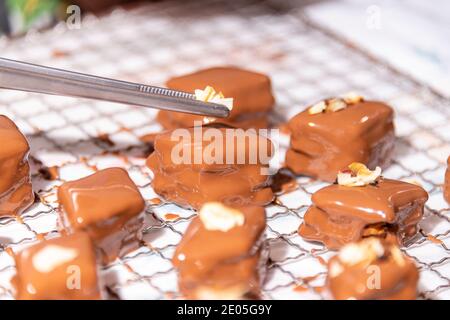 Decorare i biscotti di Natale con cioccolato al latte e nocciola Foto Stock