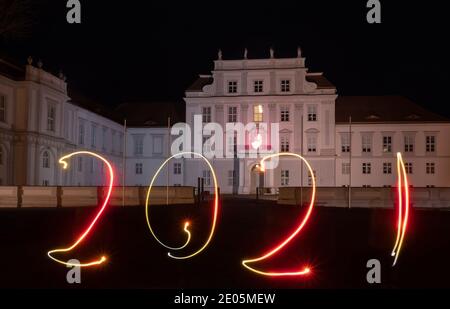 Oranienburg, Germania. 29 Dic 2020. Una donna ha disegnato l'anno 2021 con una torcia di fronte al Castello di Oranienburg (Brandeburgo). (Esposizione a lungo termine) credito: Paul Zinken/dpa/Alamy Live News Foto Stock