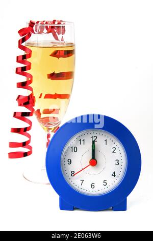 Concetto di festa di Capodanno alle 12. Un bicchiere di champagne con un orologio e un nastro festivo tagliato su uno sfondo bianco Foto Stock