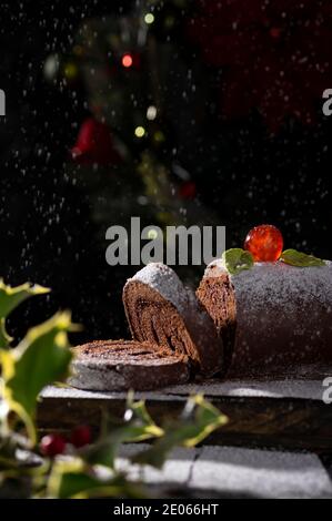 Involtini di torta svizzera al cioccolato decorata con ciliegia di zucchero e. zucchero a velo Foto Stock