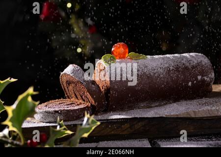 Involtini di torta svizzera al cioccolato decorata con ciliegia di zucchero e. zucchero a velo Foto Stock