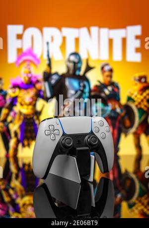 20 dicembre 2020, Odessa, Ucraina. Nuovo gamepad bianco per PlayStation 5 sullo sfondo del gioco Fortnite. Poster Fortnite cybersport. Foto Stock