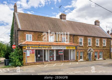 Negozi del villaggio di Snettisham chiusi e vuoti con un cartello con su "To Let" all'esterno. Foto Stock