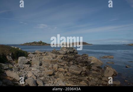 Vista panoramica dalla costa attraverso il mare dalla vecchia Grimsby sull'isola di Tresco nelle isole di Scilly, Inghilterra, Regno Unito Foto Stock