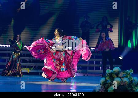 Una squadra di musicisti, cantanti e ballerini in costumi gitani che cantano e ballano sul palco Foto Stock