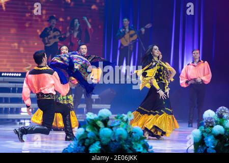 Una squadra di musicisti, cantanti e ballerini in costumi gitani che cantano e ballano sul palco Foto Stock