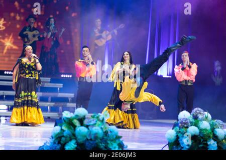 Una squadra di musicisti, cantanti e ballerini in costumi gitani che cantano e ballano sul palco Foto Stock