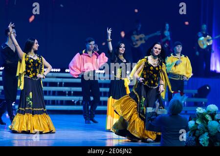 Una squadra di musicisti, cantanti e ballerini in costumi gitani che cantano e ballano sul palco Foto Stock