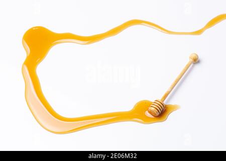 Bastone di miele, con miele versato isolato su fondo bianco Foto Stock