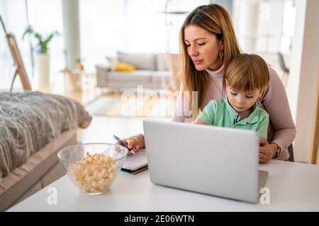 Occupato a lavorare la madre di non avere tempo per il suo bambino Foto Stock