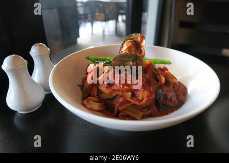 Pasta di pesce - frutti di mare in salsa di pomodoro su pappardelle Foto Stock