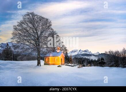 Albero di Natale vicino alla bella chiesa in montagna - alba Foto Stock