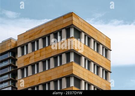 Berlino, Germania - 28 luglio 2019: Edificio di uffici di architettura moderna con facciata ventilata in pietra. Vista ad angolo basso contro il cielo Foto Stock