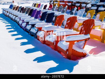Sedie colorate in stile Adirondack nella neve fresca; negozio al dettaglio; Poncha Springs; Colorado; USA Foto Stock
