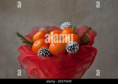 Bouquet di mandarini e rami di albero di Natale. Profumo di frutta commestibile di Capodanno. Regalo di Natale. Regalo fai da te. Regalo utile fatto di frutta. Arredamento Foto Stock