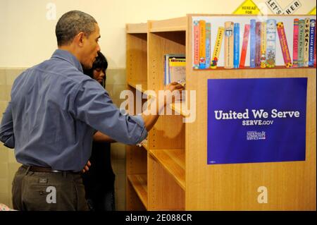 Il presidente DEGLI STATI UNITI Barack Obama aiuta a mettere in scaffali di libri come egli si unisce a volontari in una biblioteca come partecipano a un progetto di servizio, al Browne Education Center, a Washington, DC, USA, in occasione della festa nazionale Martin Luther King Jr, 16 gennaio 2012. Il progetto è stato in memoria dell'eredità del servizio comunitario, promosso dal defunto leader dei diritti civili, assassinato nel 1968. Foto di Mike Theiler/Pool/ABACAPRESS.COM Foto Stock