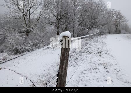 Paesaggio invernale con recinzione elettrica in primo piano. Foto Stock