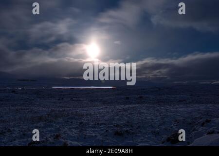 Glencoe, Scozia, Regno Unito. 30 dicembre 2020. Nella foto: Glencoe illuminato sotto la luminosità della luna piena in declino. La neve riflette la luce causando un'immagine notturna drammatica. Avvertimento giallo neve in posizione come più neve con temperature di congelamento previsto di nuovo durante la notte. Credit: Colin Fisher/Alamy Live News Foto Stock