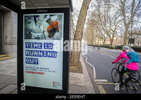 Le persone passano i poster informativi sulla Brexit nel centro di Londra mentre i deputati discuteranno e voteranno sull’accordo commerciale post-Brexit tra Regno Unito e UE, il 30 dicembre 2020 . Foto Stock