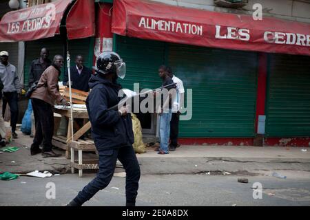 I manifestanti si scontrano con la polizia antisommossa durante una marcia di manifestazione indetta dagli attivisti dell'opposizione del movimento M23 contro la campagna del presidente senegalese Abdoulaye Wade per un controverso terzo mandato, a Dakar, il 15 febbraio 2012, in vista delle elezioni nazionali del 26 febbraio. Decine di forze di polizia hanno spinto indietro gruppi di manifestanti dell'opposizione che hanno tentato di convergere nel sobborgo di Medina, più tardi sparando gas lacrimogeni mentre hanno cercato di iniziare la marcia a Piazza Indipendenza nel cuore della città guidata dal candidato presidenziale Ibrahima caduta. Foto di Julien Tack/ABACAPRESS.COM Foto Stock