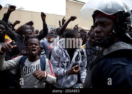 I manifestanti si scontrano con la polizia antisommossa durante una marcia di manifestazione indetta dagli attivisti dell'opposizione del movimento M23 contro la campagna del presidente senegalese Abdoulaye Wade per un controverso terzo mandato, a Dakar, il 15 febbraio 2012, in vista delle elezioni nazionali del 26 febbraio. Decine di forze di polizia hanno spinto indietro gruppi di manifestanti dell'opposizione che hanno tentato di convergere nel sobborgo di Medina, più tardi sparando gas lacrimogeni mentre hanno cercato di iniziare la marcia a Piazza Indipendenza nel cuore della città guidata dal candidato presidenziale Ibrahima caduta. Foto di Julien Tack/ABACAPRESS.COM Foto Stock