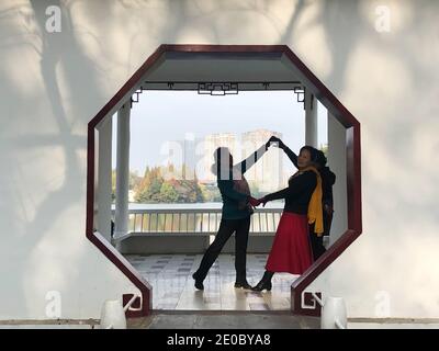 Hefei, provincia cinese di Anhui. 29 Nov 2020. La gente danza accanto ad una porta ottagonale nel Parco di Huancheng a Hefei, capitale della Provincia di Anhui della Cina orientale, 29 novembre 2020. Credit: Zhang Duan/Xinhua/Alamy Live News Foto Stock