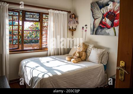 Foto orizzontale di una camera da letto retrò per bambini con un teddy appoggiarsi sul letto Foto Stock