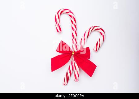 Natale Candy Cane con fiocco rosso isolato su sfondo bianco. Foto Stock