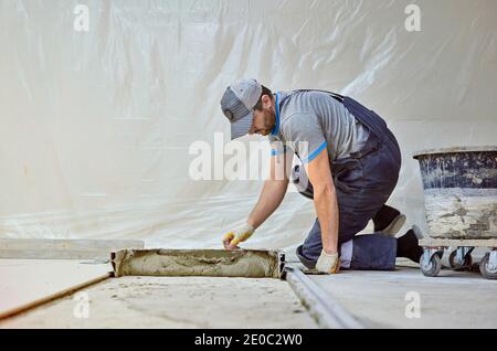 l'uomo pone il gres su un luogo di costruzione Foto Stock