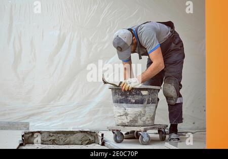 l'uomo pone il gres su un luogo di costruzione Foto Stock