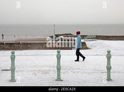 Portobello, Edimburgo, Scozia, Regno Unito. 31 dicembre 2020. Tempo nel Regno Unito: Dopo l'alba colorata, il porty ha avuto una doccia di neve presto, al mare. Nella foto: Questa donna fuori esercitarsi camminando l'ultimo giorno di 2020. Credit: Arch White/Alamy Live News. Foto Stock