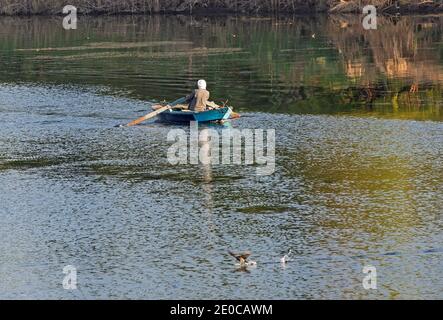 Tradizionale beduino egiziano pescatore in barca a remi sul fiume Nilo Pesca da riva Foto Stock