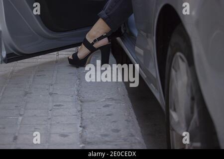 Primo piano irriconoscibile di una scarpa alta tacco di una donna di affari elegante e di successo che esce dalla sua auto per andare al lavoro. Concetto di Boss ragazza 2021. Foto Stock