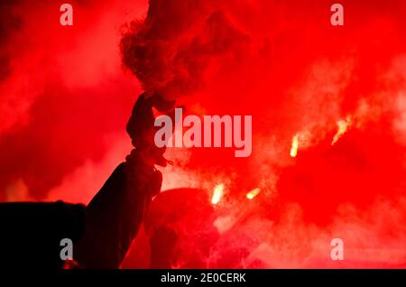 Il protesore sta tenendo un fuoco ardente nelle sue mani. Il tifoso del calcio brucia il fuoco Foto Stock