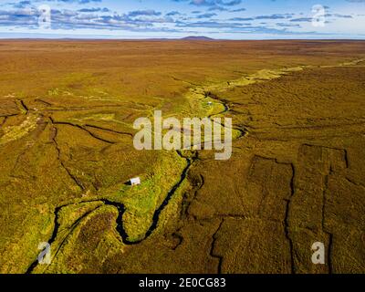 Aereo di una piccola capanna in Moorland sull'Isola di Lewis, Ebridi esterne, Scozia, Regno Unito, Europa Foto Stock