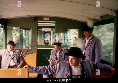 Germania/Baviera/ uomo in costume tradizionale che viaggia su un treno nostalgico. Foto Stock