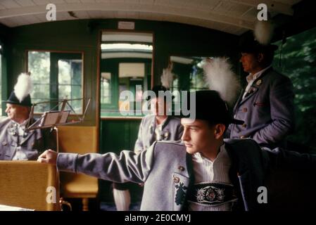 Germania/Baviera/ uomo in costume tradizionale che viaggia su un treno nostalgico che guarda fuori dalla finestra. Foto Stock