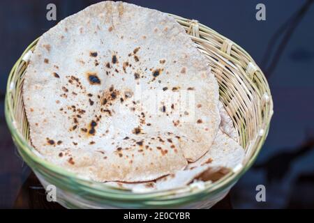 Fuoco selettivo del pane indiano Roti o Chapati con un cesto di bambù fatto a mano. Foto Stock