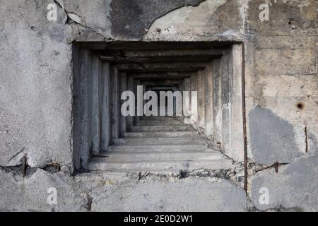 Dettaglio bunker militare e pillbox - abbraccio steppen e foro per pistola nella parete grigia in cemento. Foto Stock