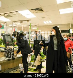 Londra UK, dicembre 31 2020, acquirenti di donne che utilizzano le postazioni di pagamento self-service automatizzate nel Supermarket Waitrose per UN check-out veloce Foto Stock