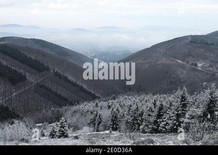 Valle in montagna Beskid, Repubblica Ceca / Czechia - colline e natura in inverno. Vista da Radegast. Trojanovice villaggio in lontananza. Foto Stock