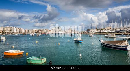 Barche a vela ormeggiate nel porto di Sliema sullo sfondo panoramico di la Valletta, Malta Foto Stock