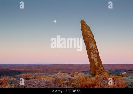 Vecchia pietra di confine (inizio del 1700) su Blakey Rigg guardando ad ovest all'alba nel parco nazionale di North York Moors. Comprende una luna quasi piena e la B Foto Stock