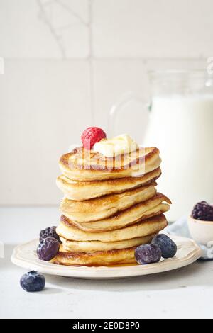Frittelle soffici per la colazione con sciroppo d'acero e frutti di bosco Foto Stock
