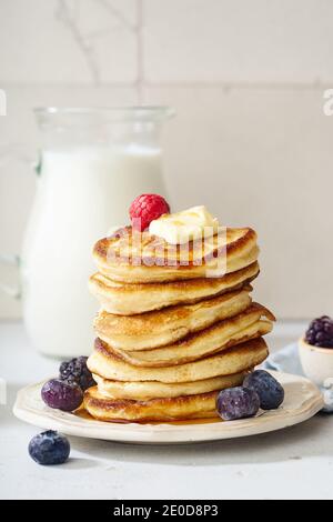 Frittelle soffici per la colazione con sciroppo d'acero e frutti di bosco Foto Stock