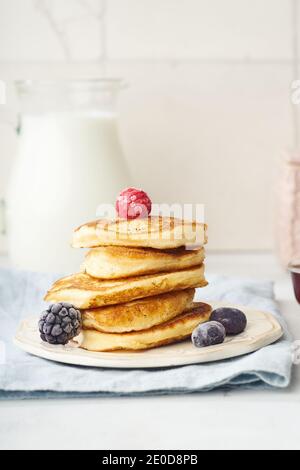 Frittelle soffici per la colazione con sciroppo d'acero e frutti di bosco Foto Stock